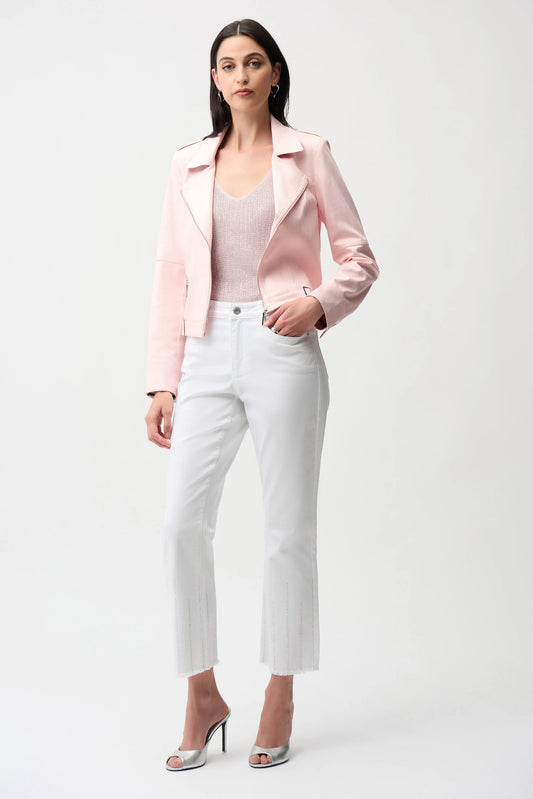 Woman wearing a pink blazer, white top, and white pants on a white background