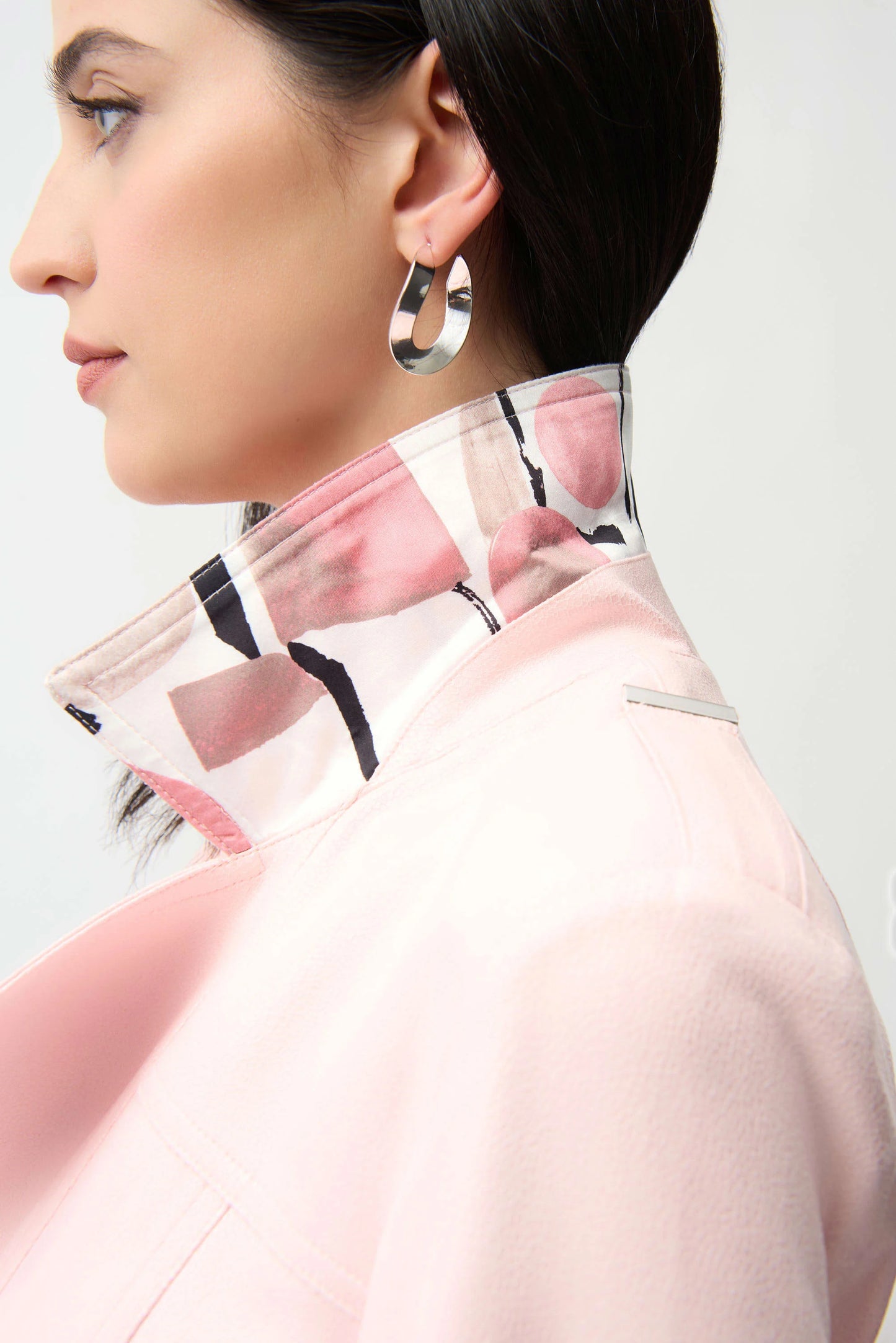 Close-up of a person wearing a pink jacket with a white background