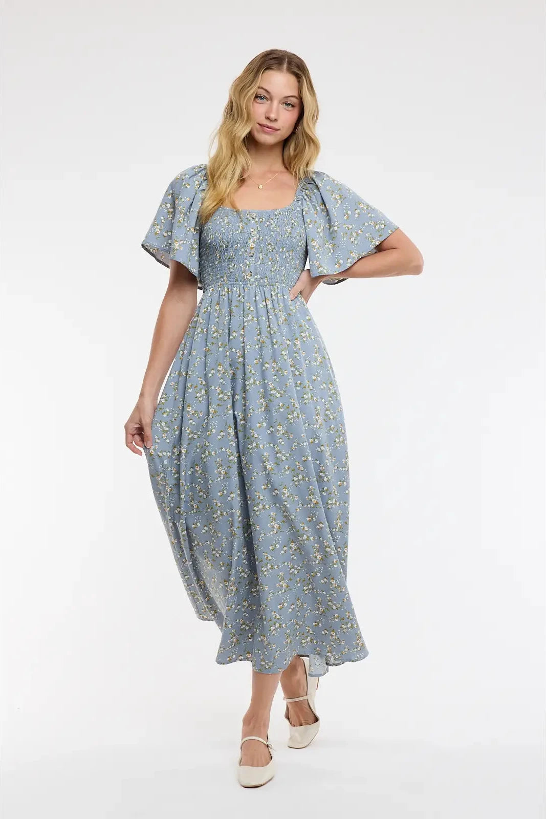 Woman wearing a blue floral dress on a white background