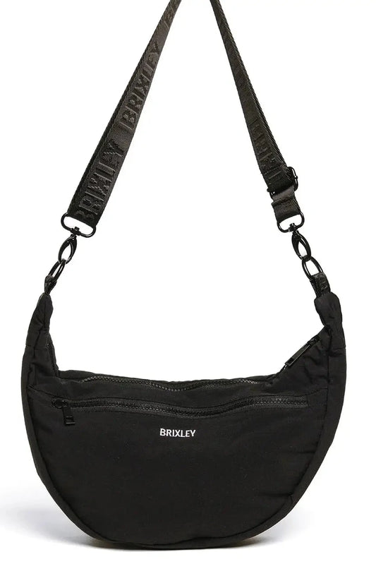 A black crescent-shaped nylon shoulder bag with a wide, adjustable black webbed strap featuring the brand name 'BRUXLEY' in white. The front of the bag has a zippered pocket with the 'BRUXLEY' logo printed in white, and the bag is photographed on a clean white background.