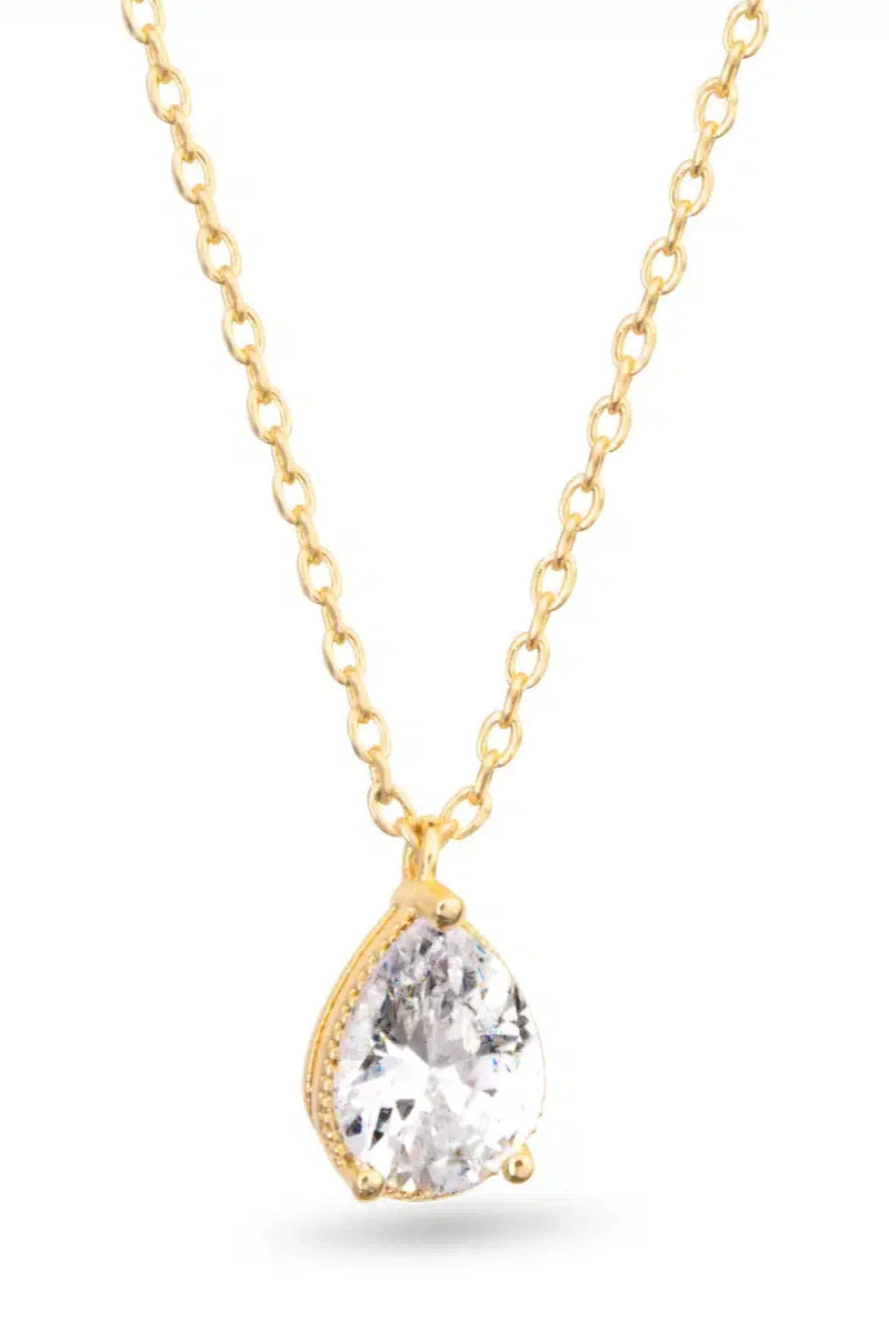 Gold necklace with a teardrop-shaped clear gemstone on a white background