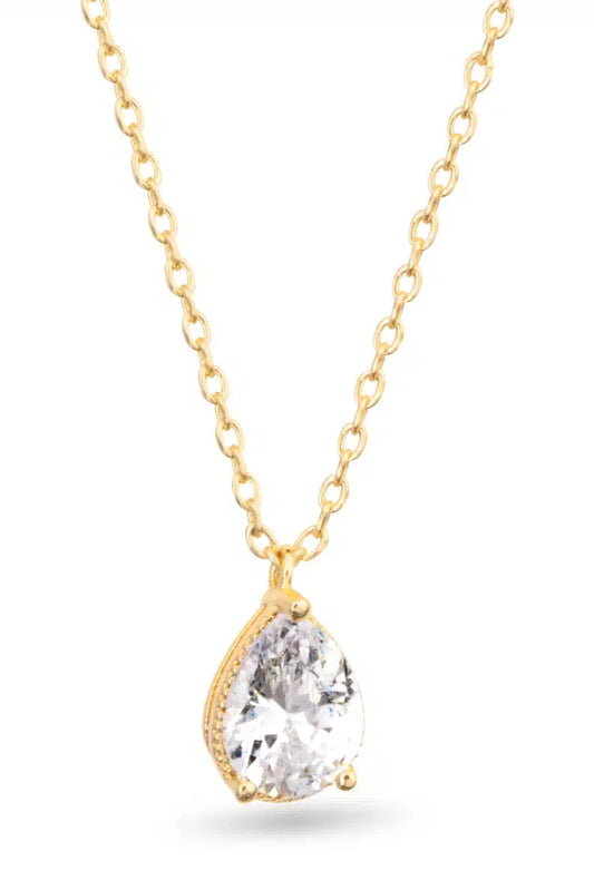 Gold necklace with a teardrop-shaped clear gemstone on a white background
