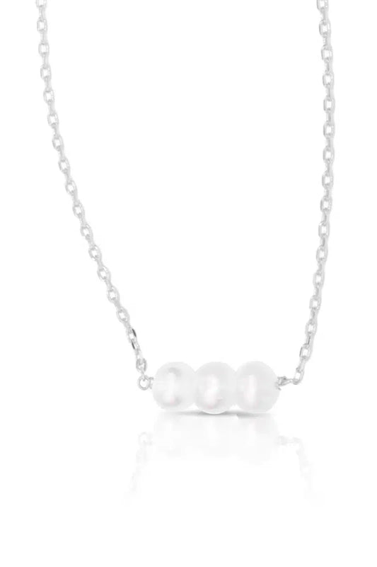 Silver necklace with 3 pearls on a white background