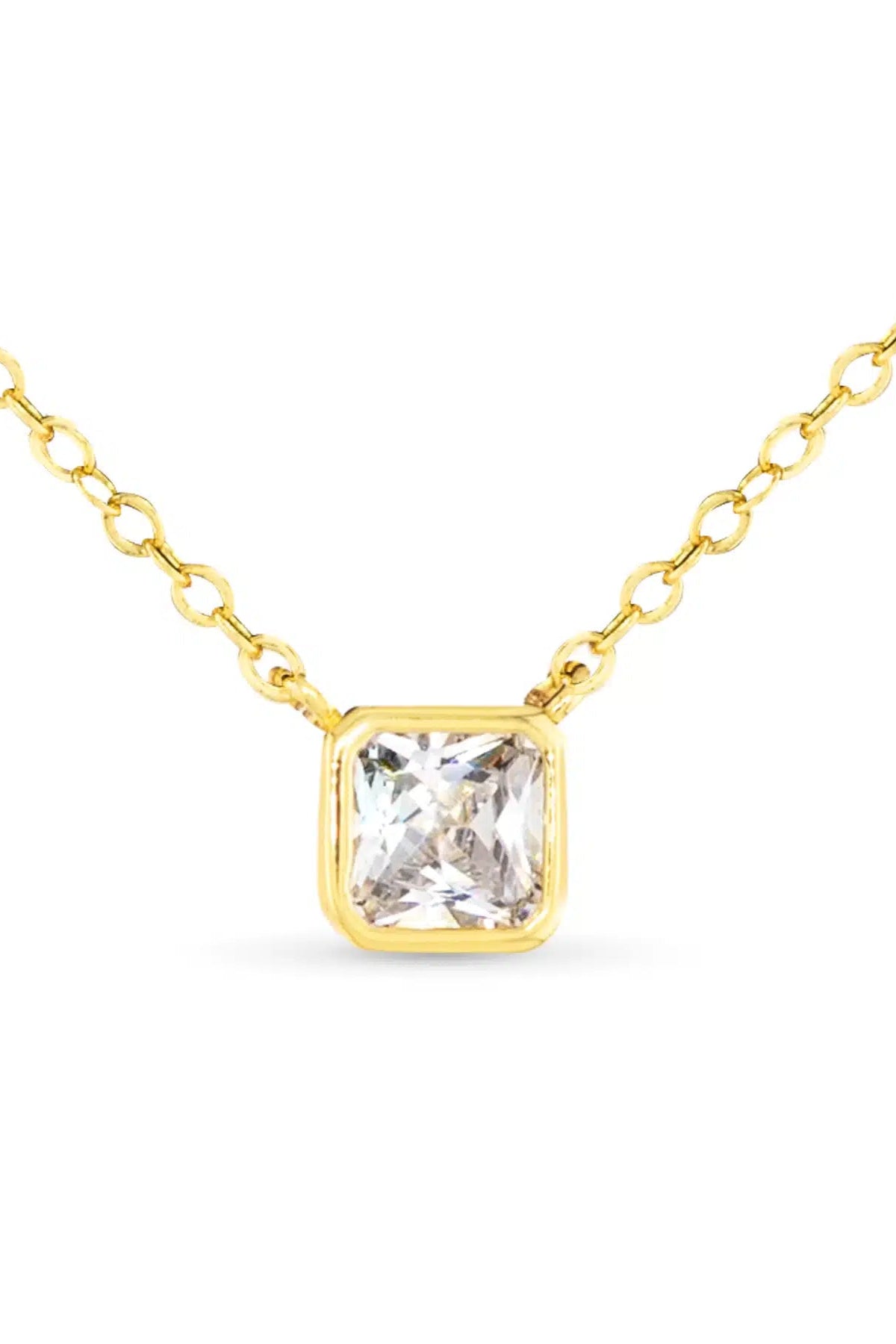 Gold necklace with a clear gemstone on a white background