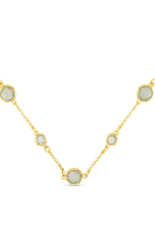 Gold necklace with round gemstones on a white background