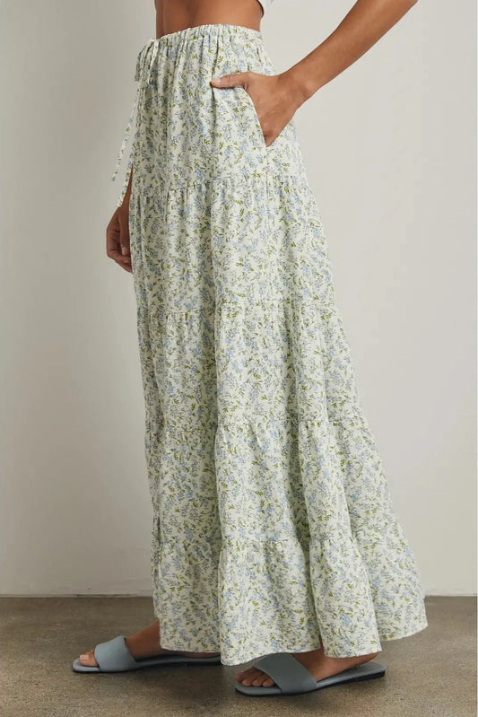 Person wearing floral-patterned pants with a neutral background