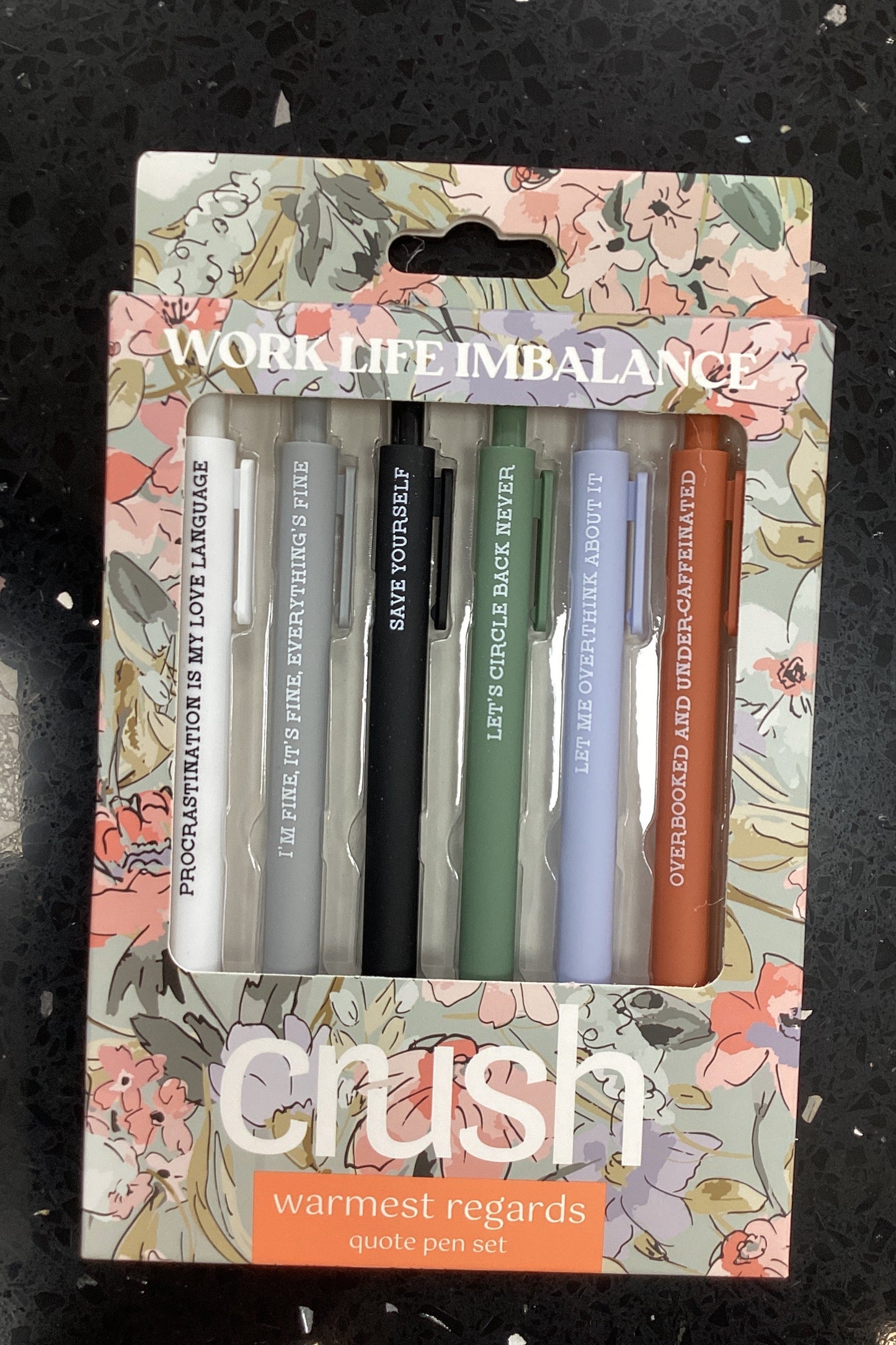 Set of pens in a floral-patterned holder with 'Gush' branding.