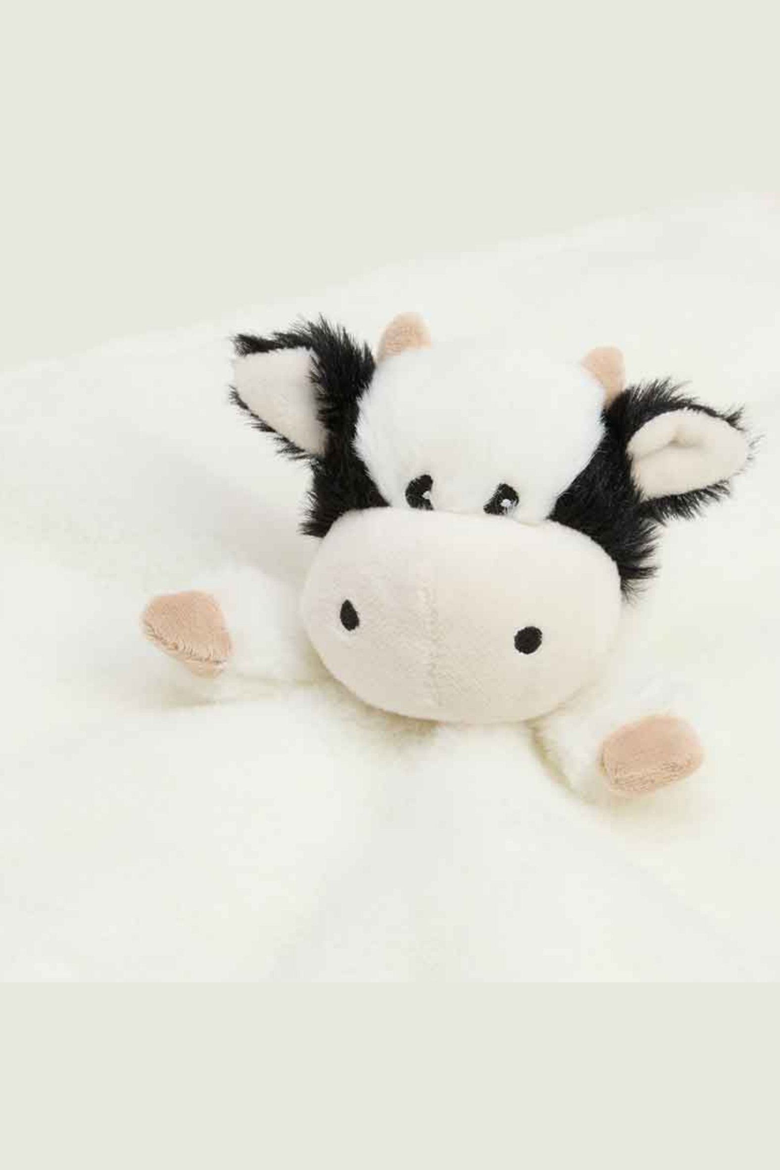 Plush cow toy on a white background