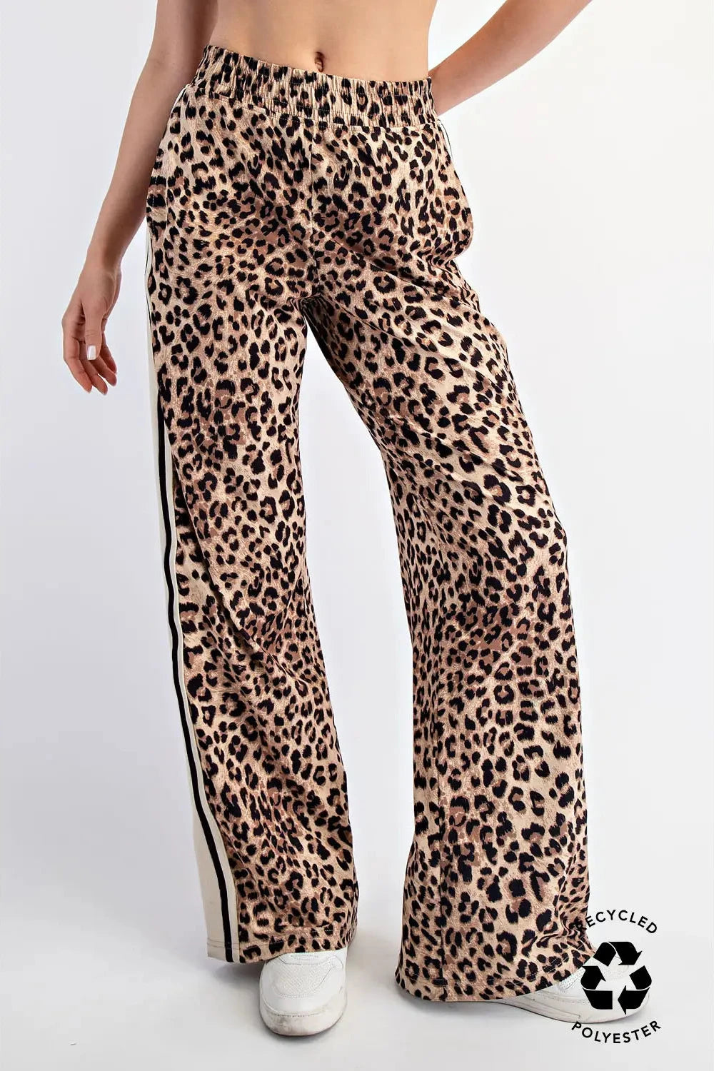 Leopard print pants with a visible recycling logo on a white background