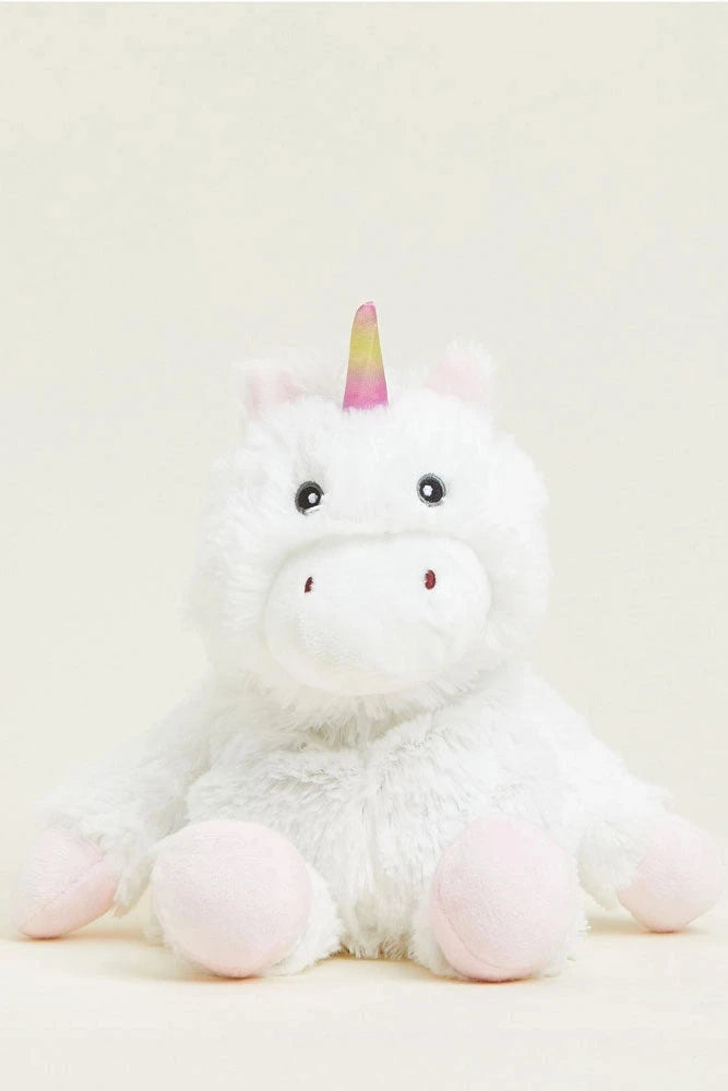 A white plush unicorn toy with pink hooves and a pastel rainbow-colored horn, sitting against a soft cream background.