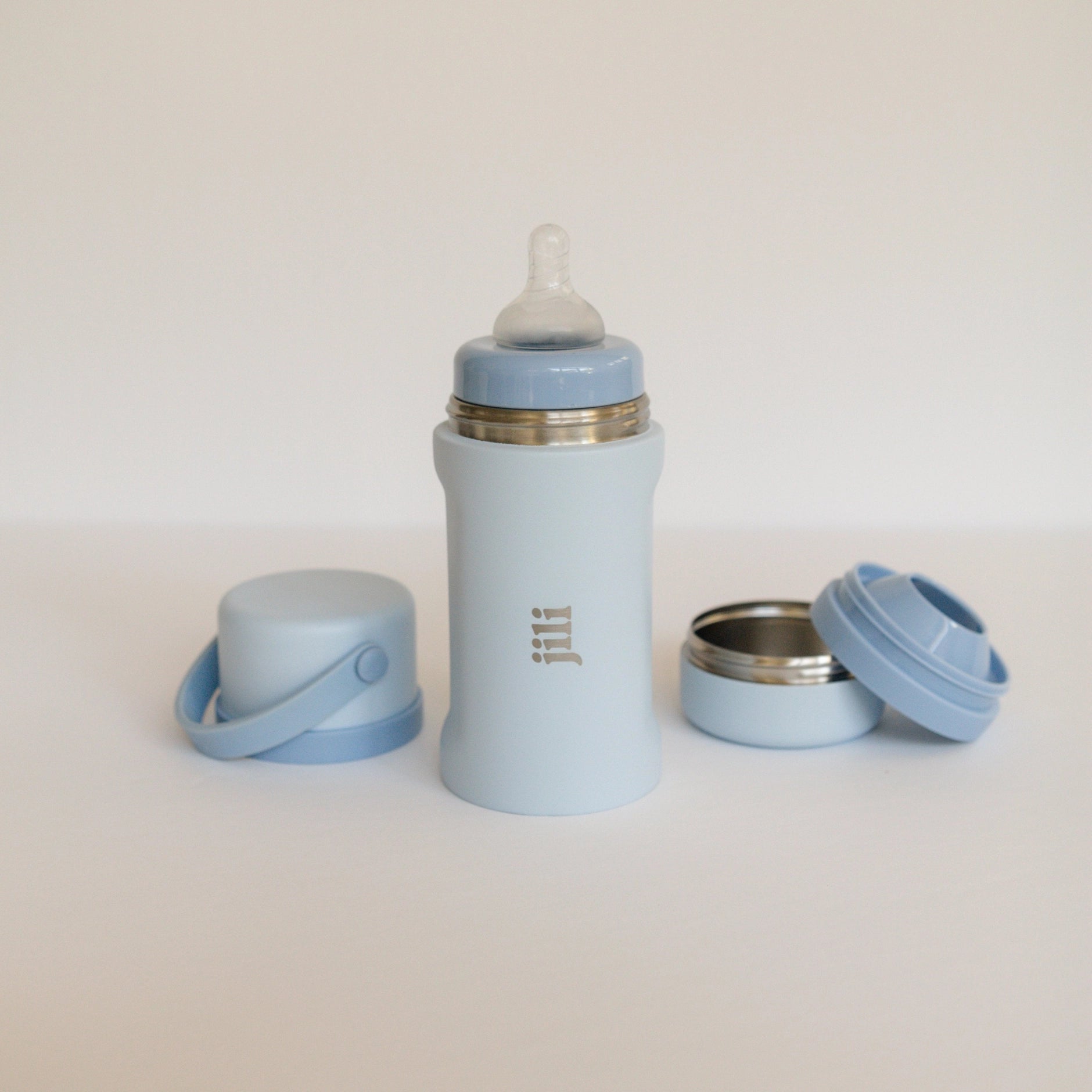 Light blue baby bottle and accessories on a white background