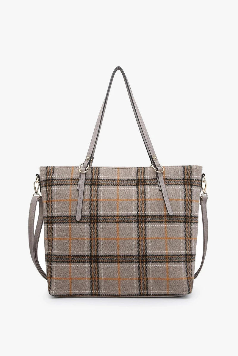 Plaid patterned handbag with shoulder straps on a white background
