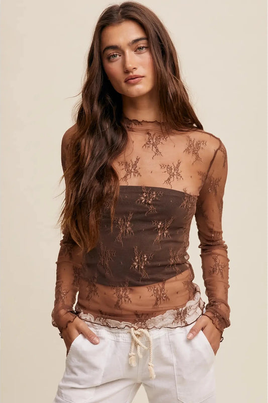 Woman wearing a brown lace top with long sleeves against a beige background