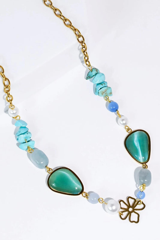 Necklace with turquoise beads and a gold chain on a white background