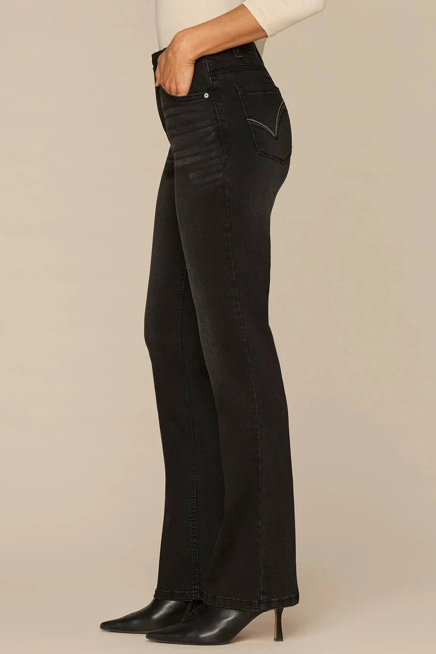 Black jeans worn by a person on a beige background