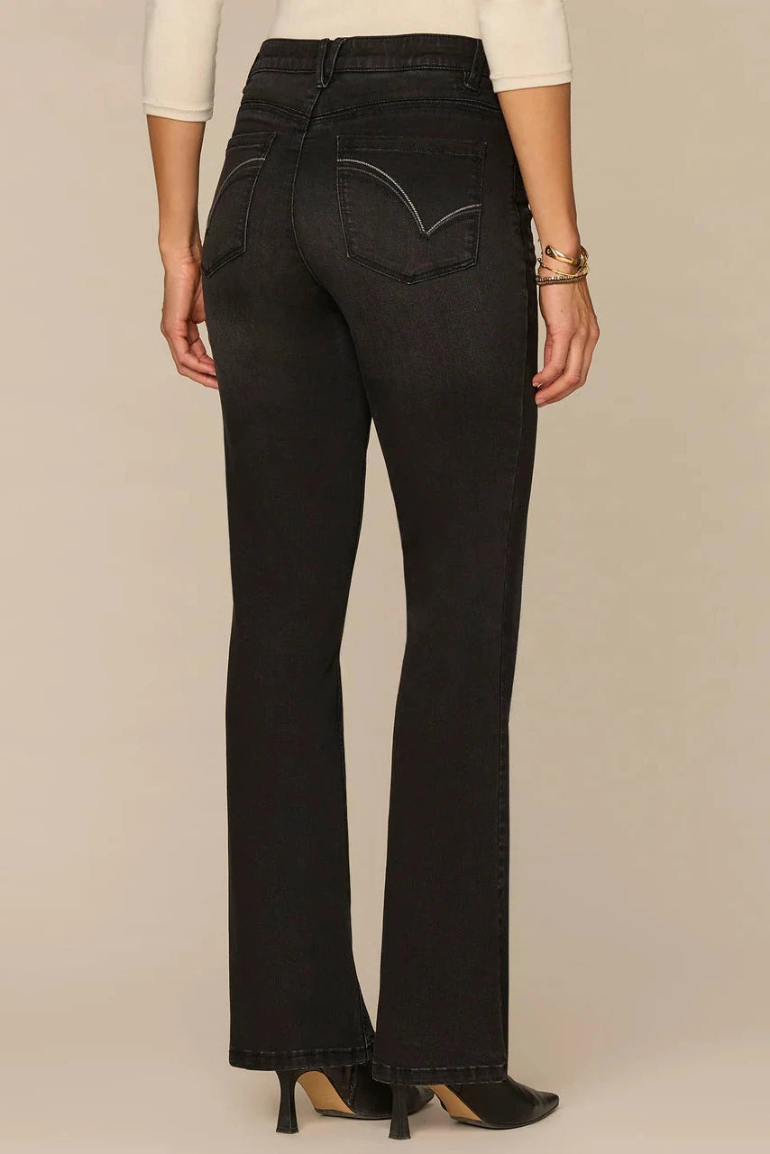 Black jeans worn by a person on a beige background
