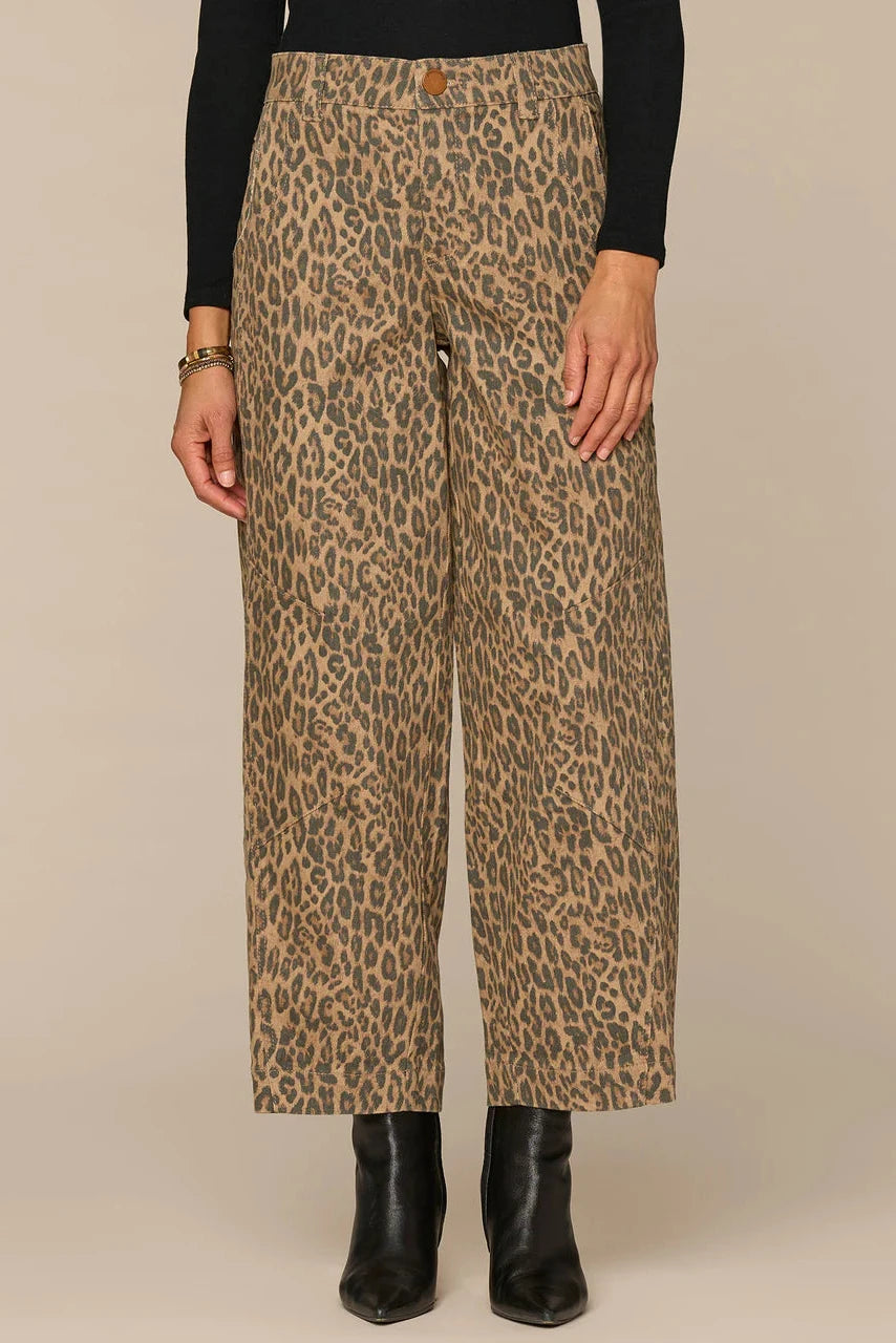 Leopard print pants worn by a person on a beige background