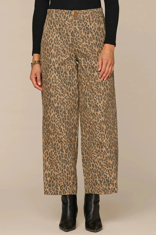 Leopard print pants worn by a person on a beige background