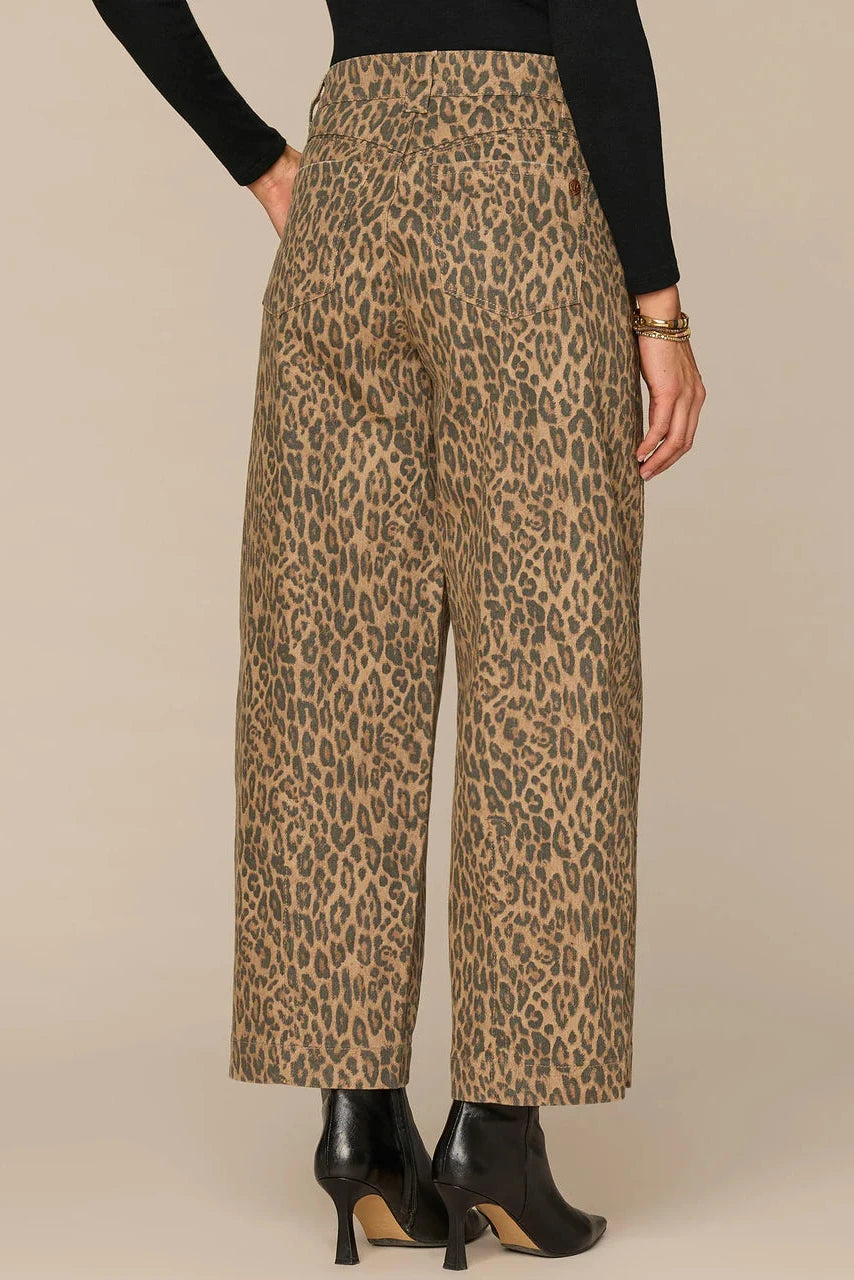 Leopard print pants worn by a person on a beige background