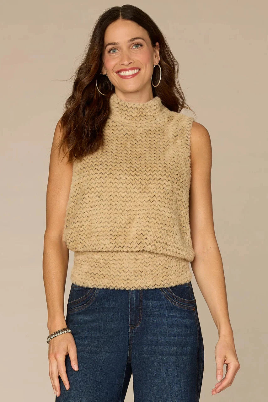 Woman wearing a beige knitted sleeveless top against a beige background