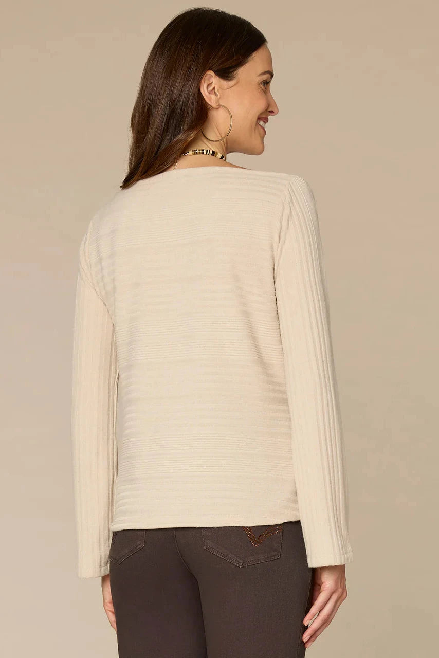 Woman wearing a beige sweater against a beige background