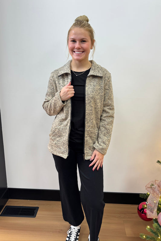 Person standing in front of a Christmas tree with lights and decorations.
