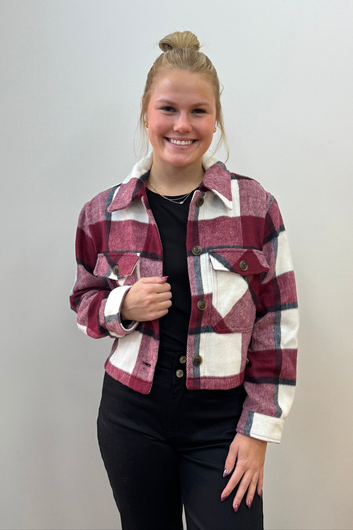 Person wearing a plaid jacket on a plain background