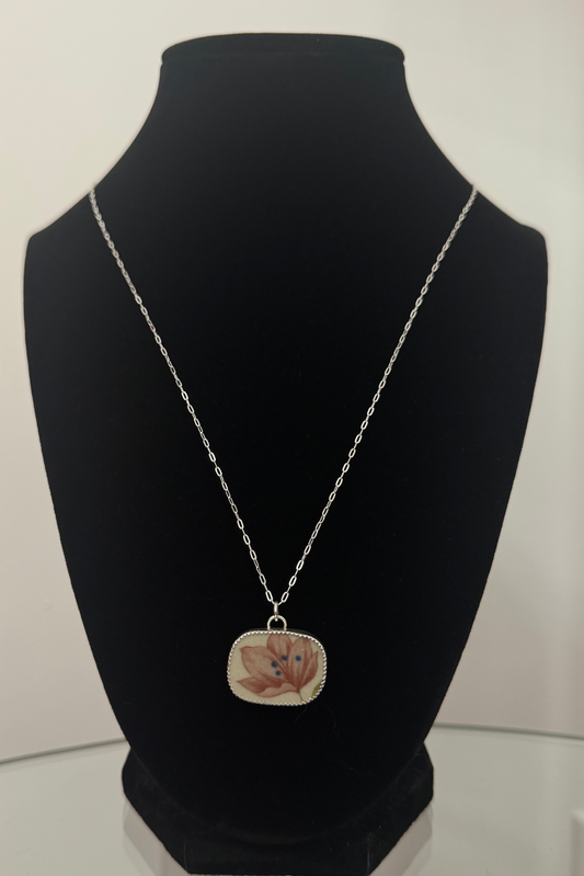 Necklace with a pendant on a black mannequin bust against a white background