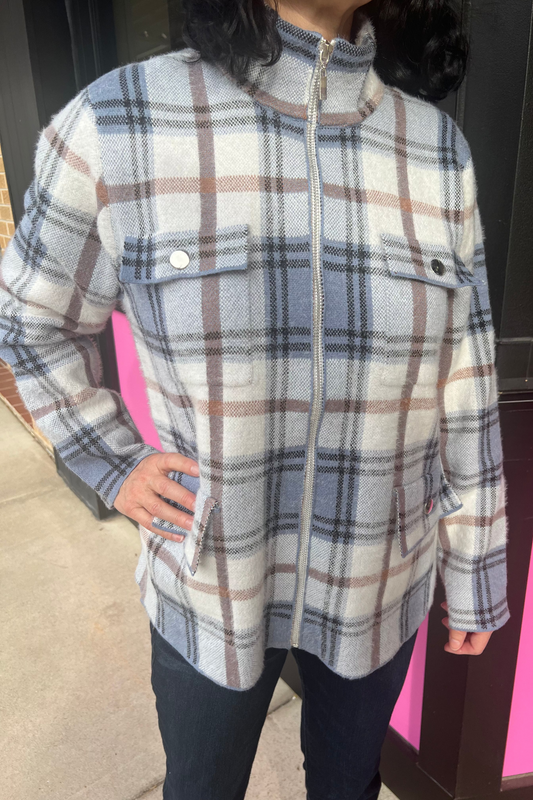 Person wearing a plaid jacket in front of a pink and black background