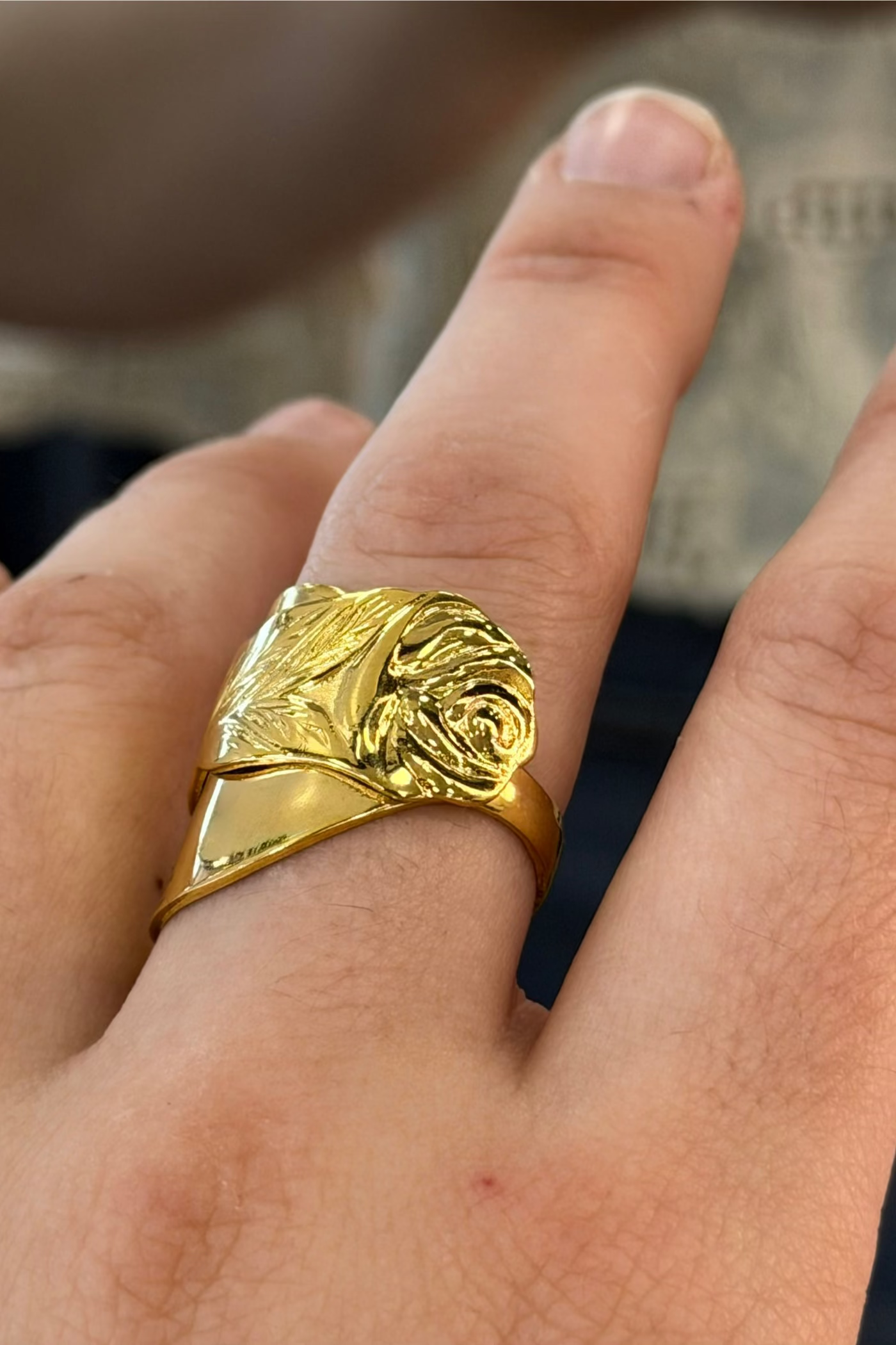 Gold plated ring with a rose design. Shown on finger