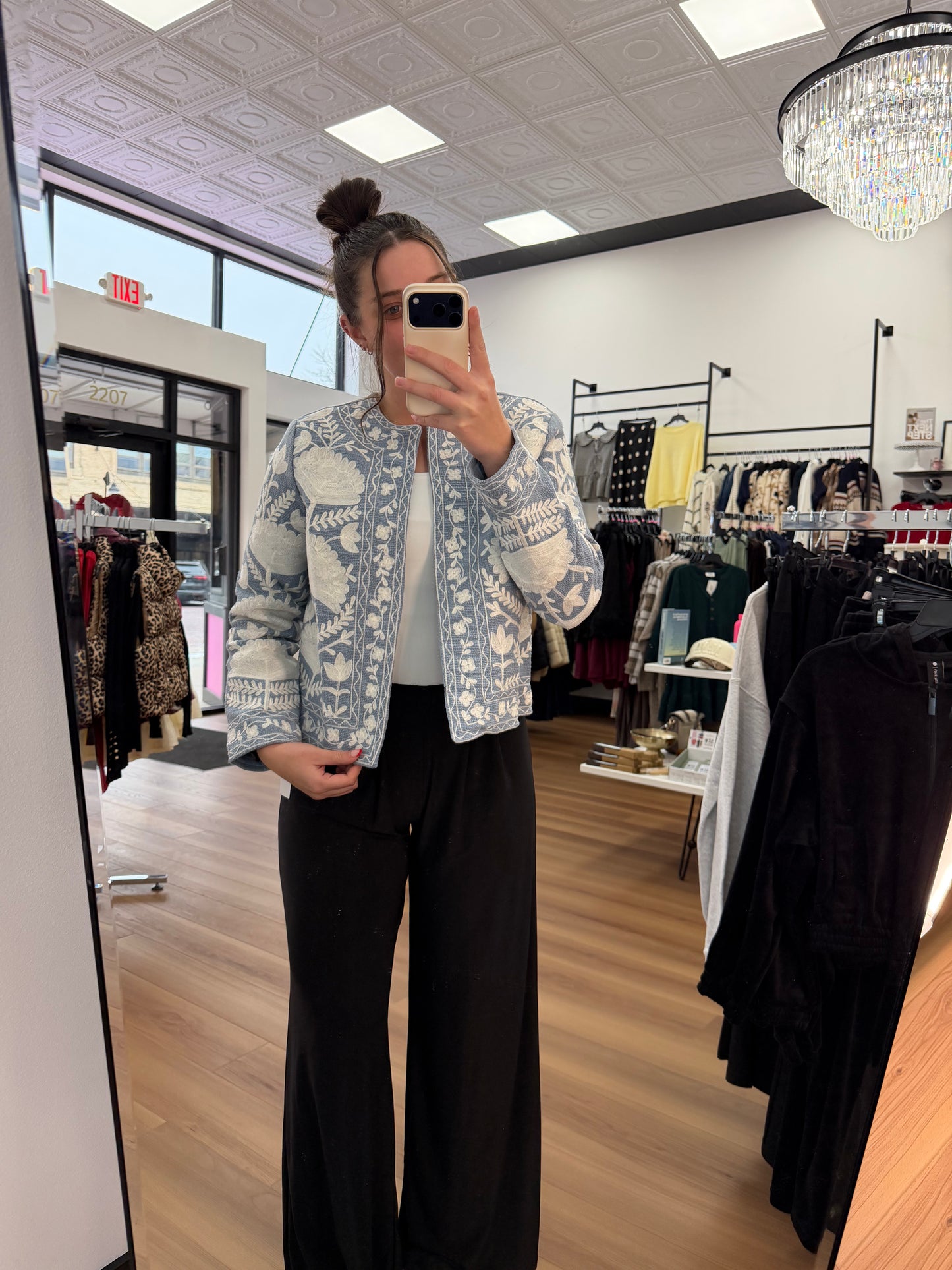 Person wearing a patterned jacket in a clothing store
