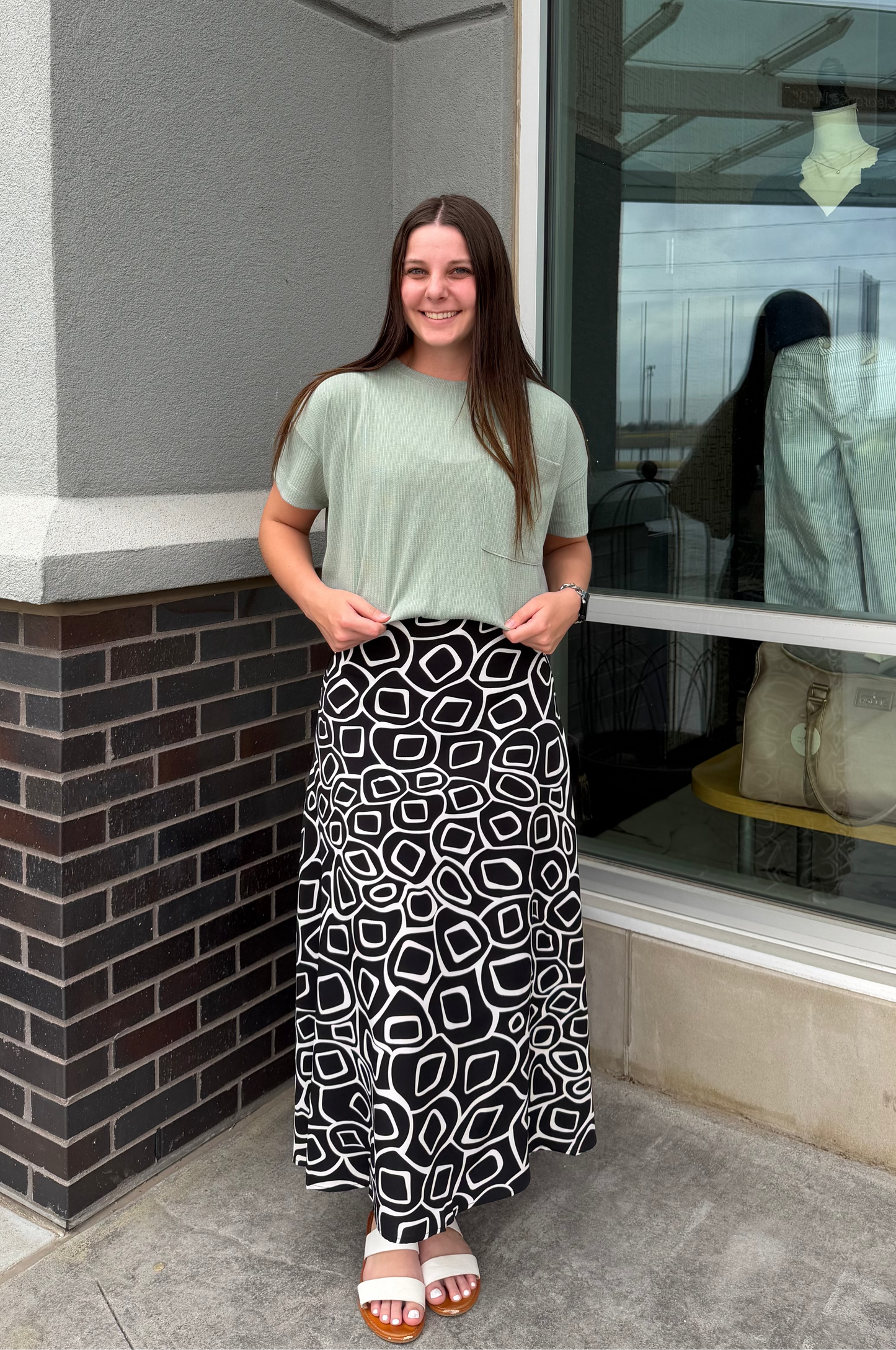 Woman standing outside a store with a window display.