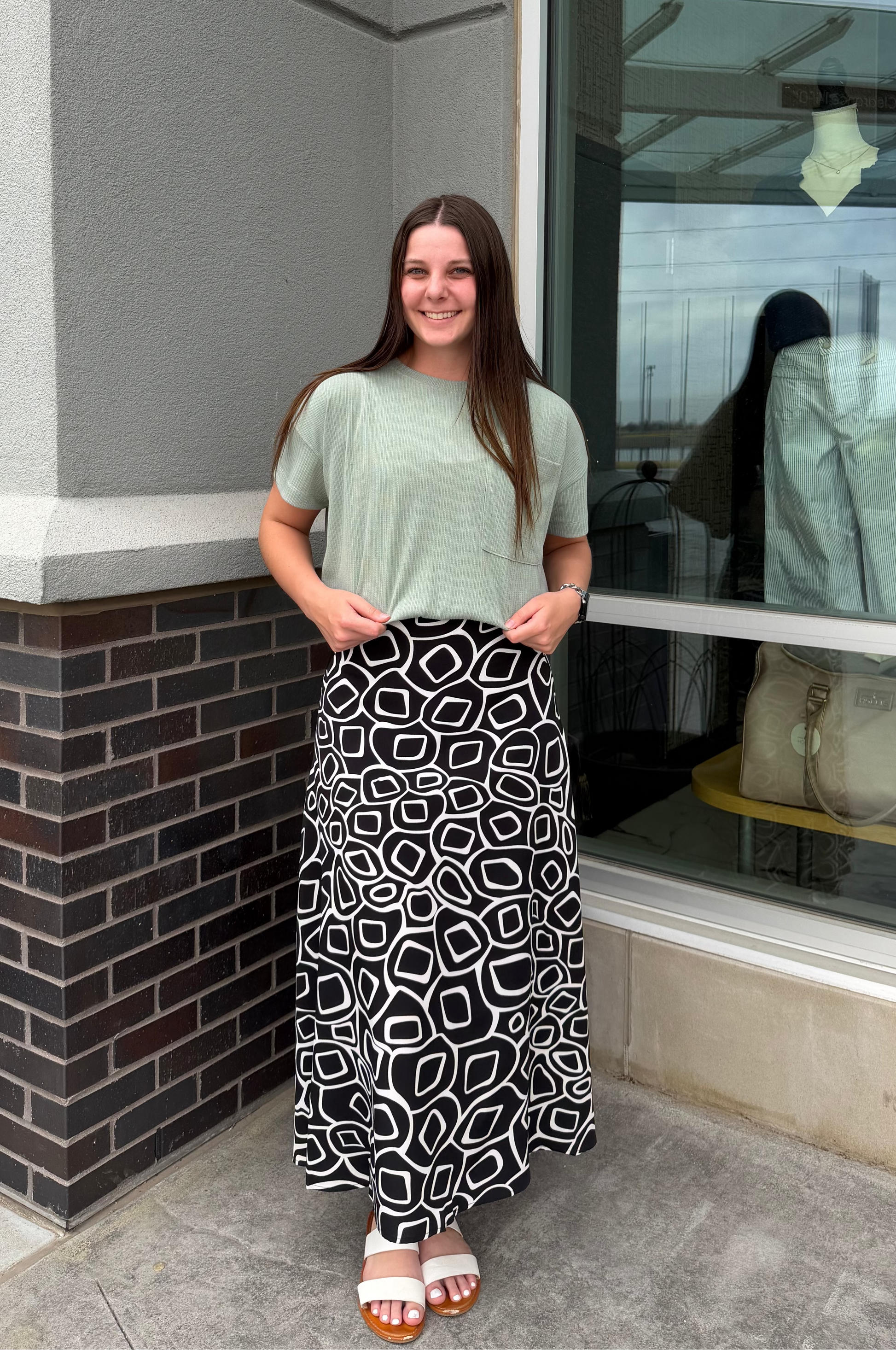 Woman standing outside a store with a window display.