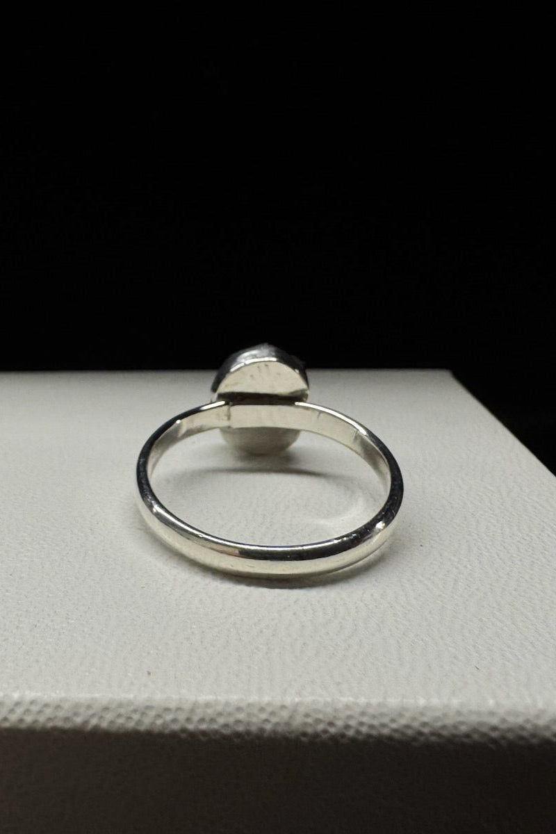 Silver ring on a white box with a black background