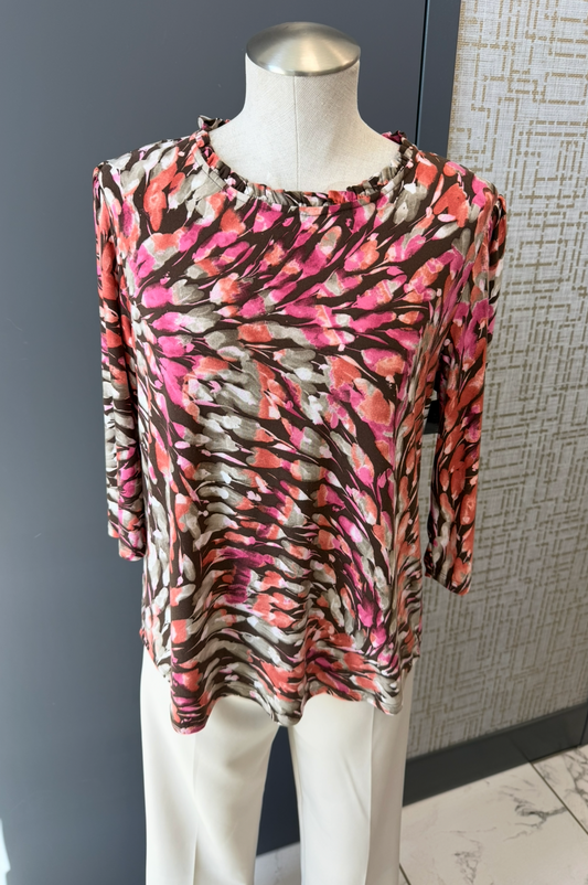Mannequin wearing a colorful patterned top against a neutral background