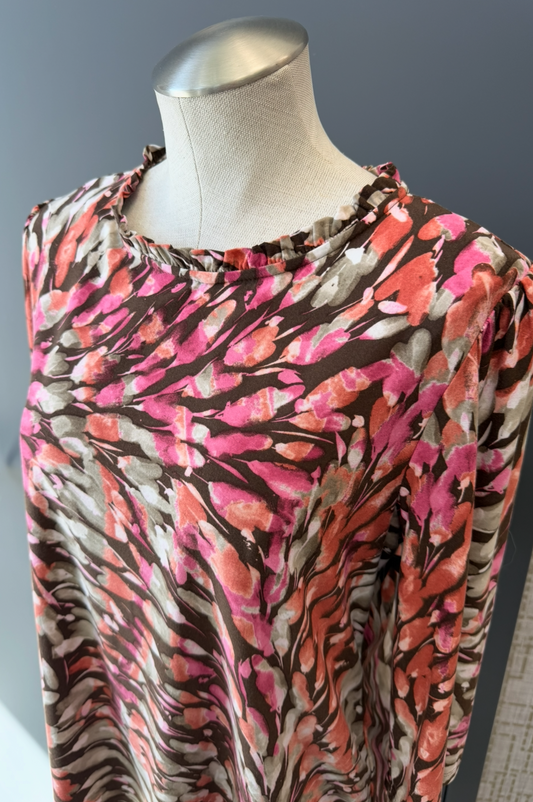 Mannequin wearing a colorful patterned dress against a neutral background