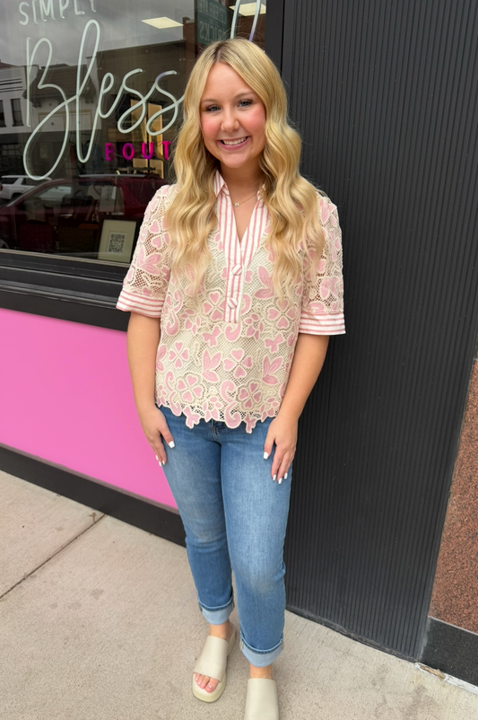 Woman standing in front of a store with a pink and black exterior.
