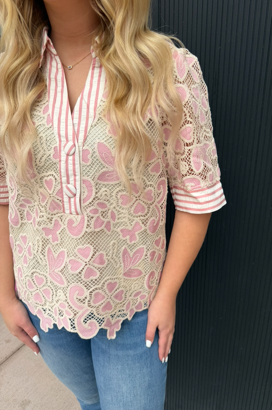 Woman wearing a pink lace blouse with a black background