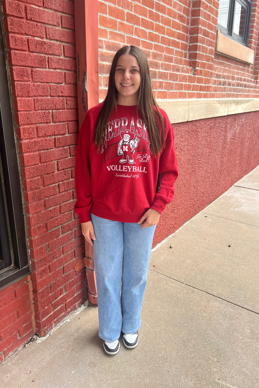 Person wearing a red sweatshirt with a Husker logo