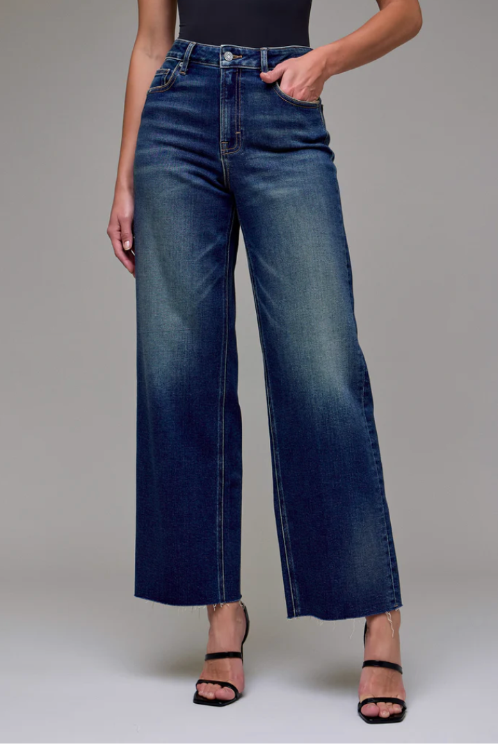 Person wearing blue jeans on a gray background