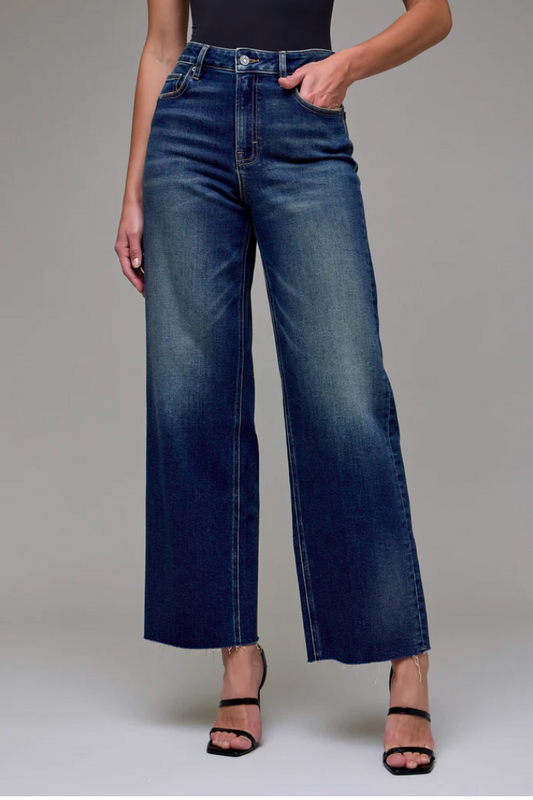 Person wearing blue jeans on a gray background