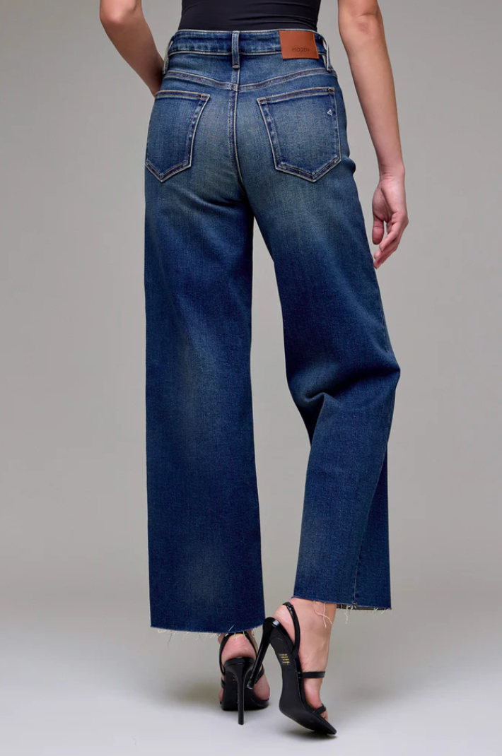 Blue jeans worn by a person on a plain background