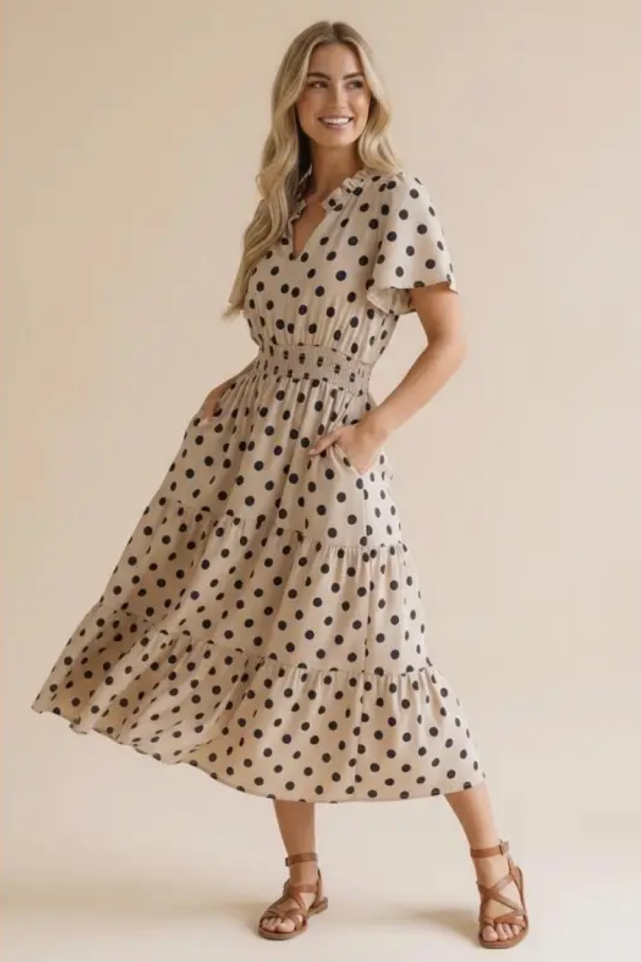 Woman wearing a polka dot dress against a beige background