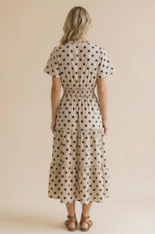 Woman wearing a polka dot dress against a beige background