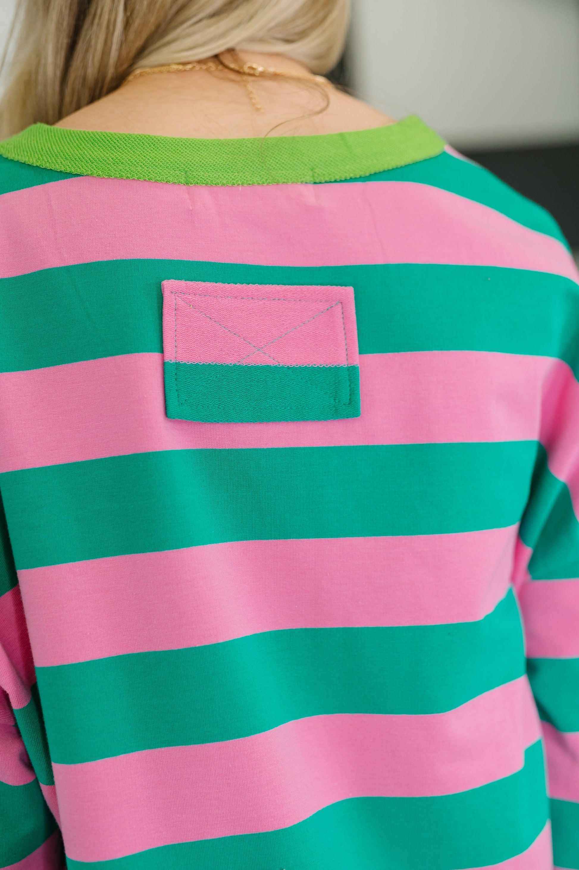 Pink and green striped shirt with a pocket on a blurred background