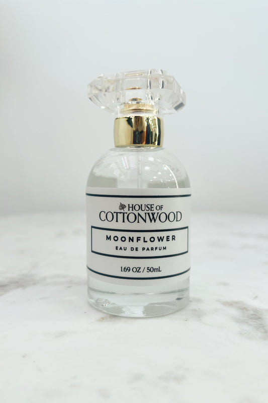Perfume bottle labeled 'House of Cottonwood' on a marble surface