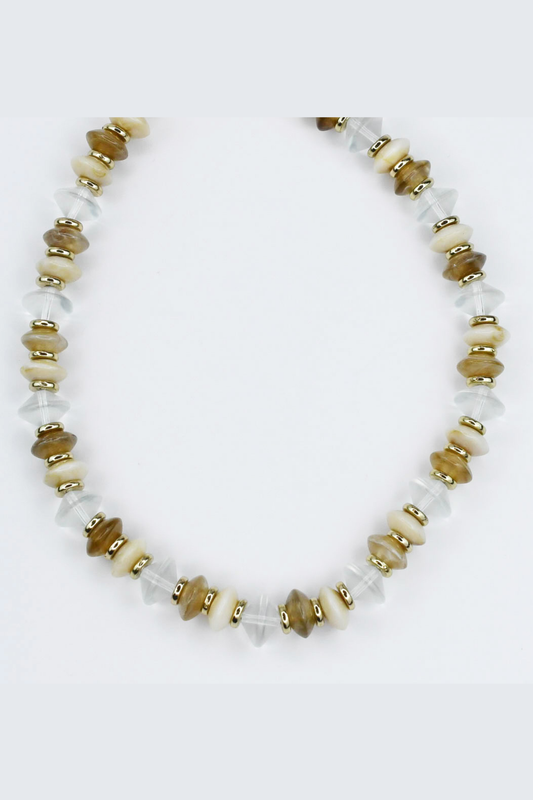 Necklace with white, gold, and brown beads on a light gray background