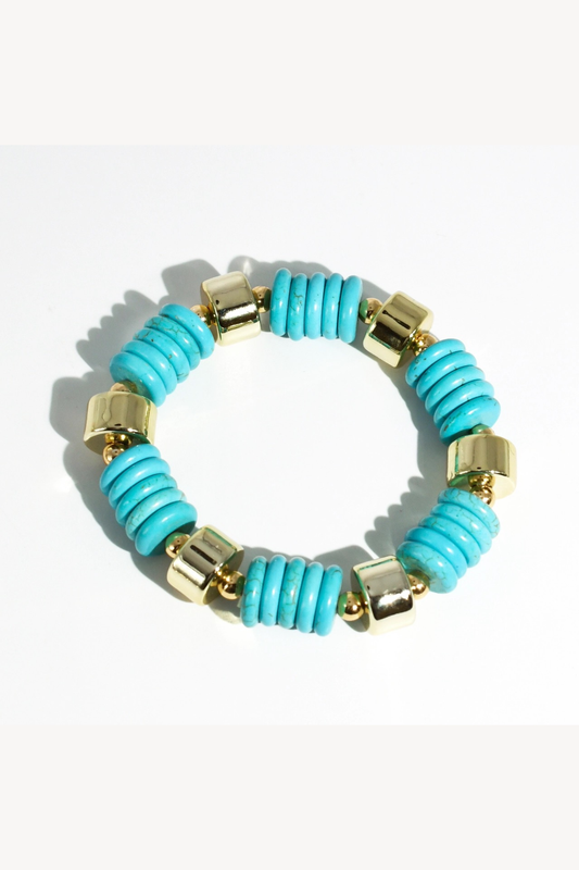 Turquoise beaded bracelet with gold accents on a white background