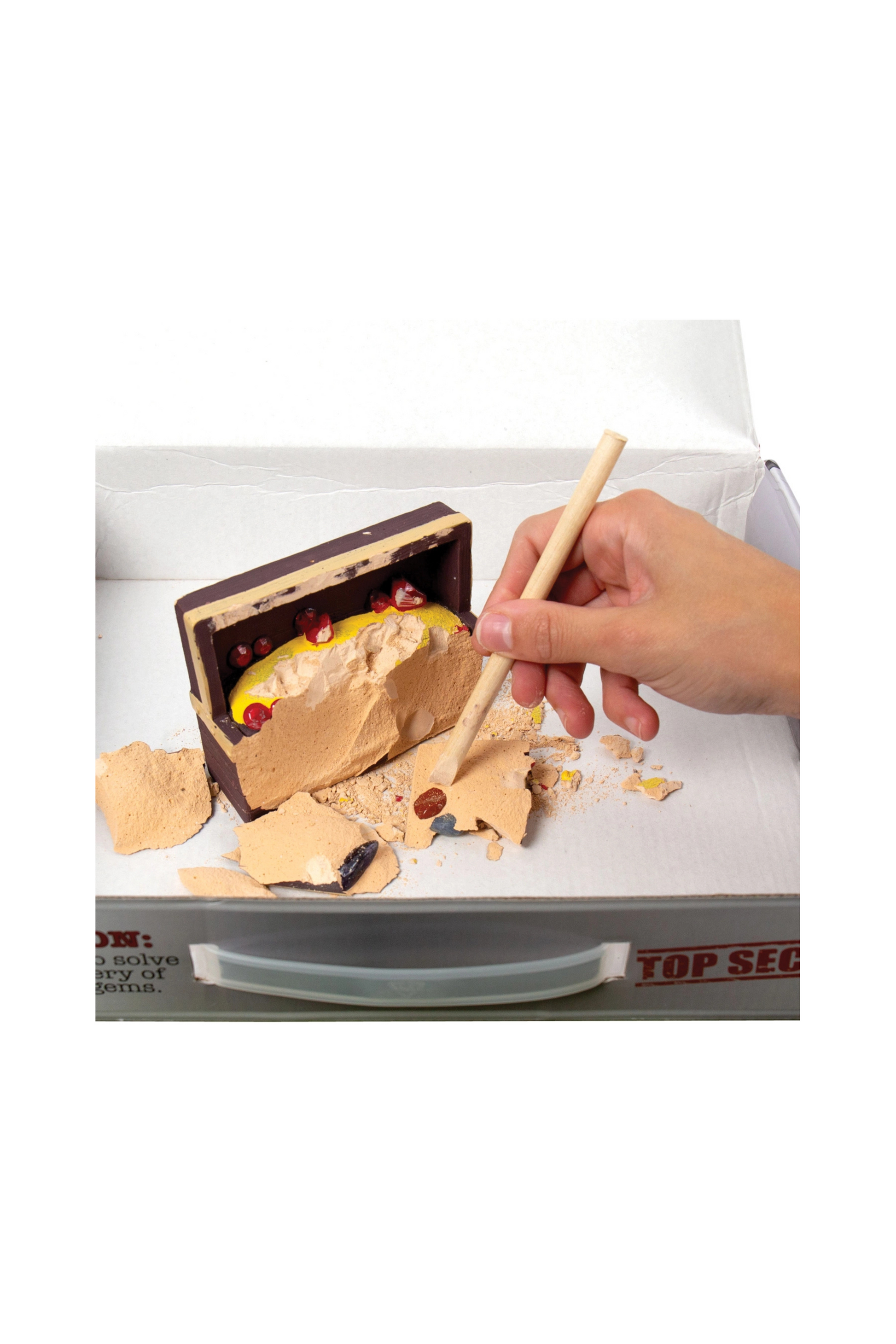 Hand using a stick to interact with a dessert in a box labeled 'Top Secret'.
