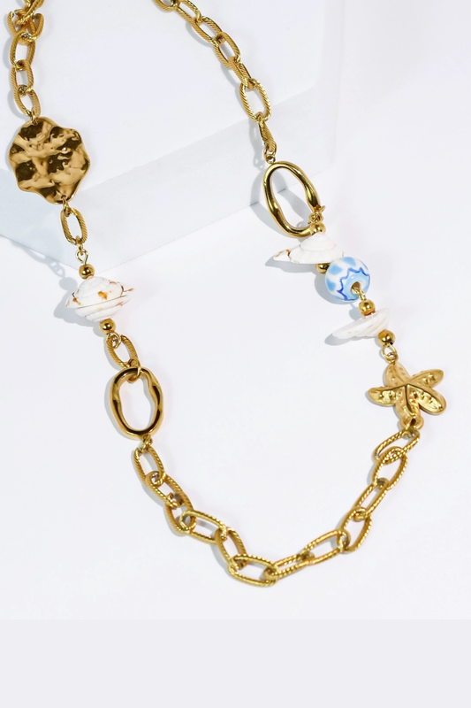 Gold chain necklace with various beads on a white background